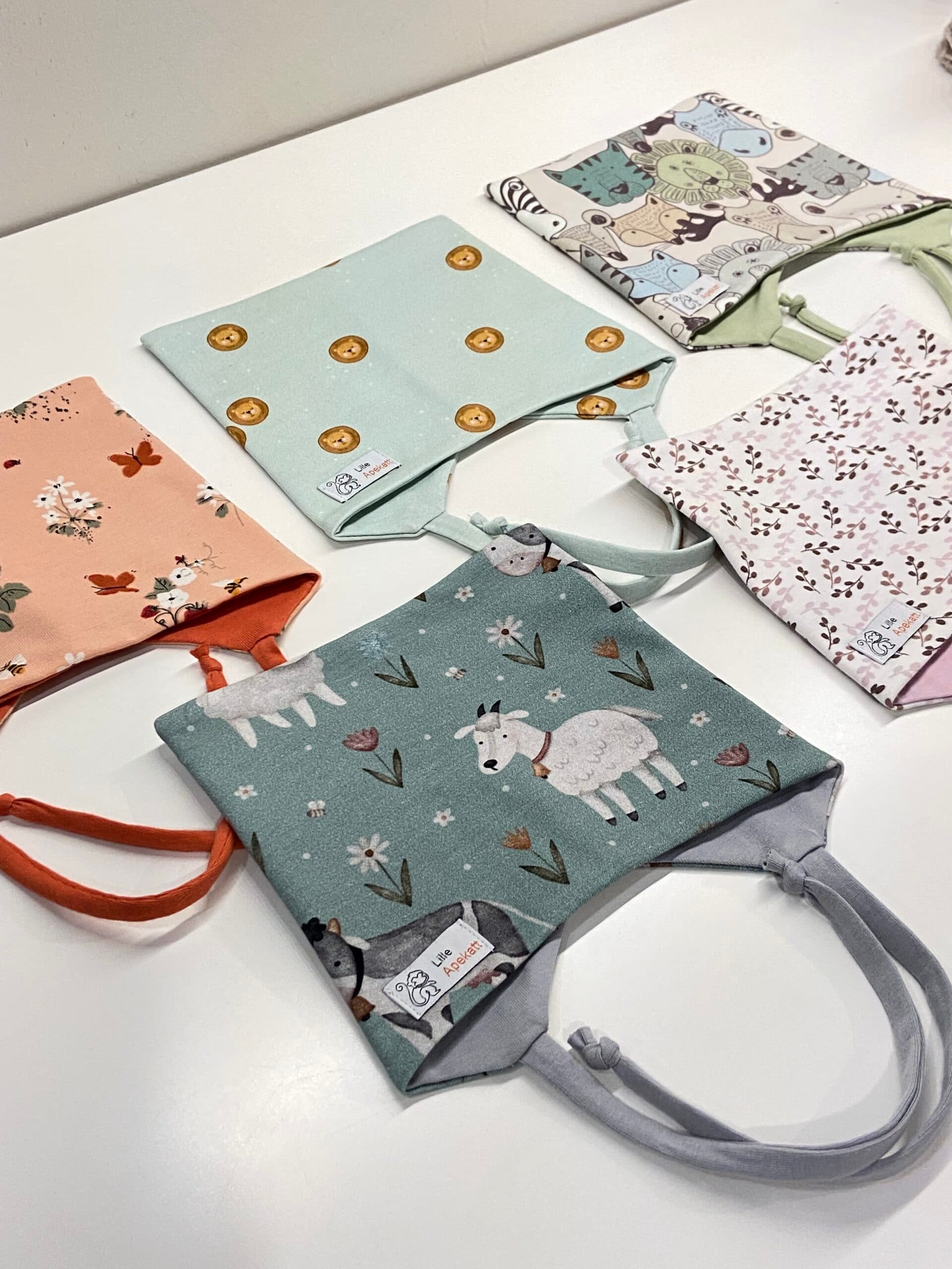 Lue med knyting, blomstereng. 4-12mnd