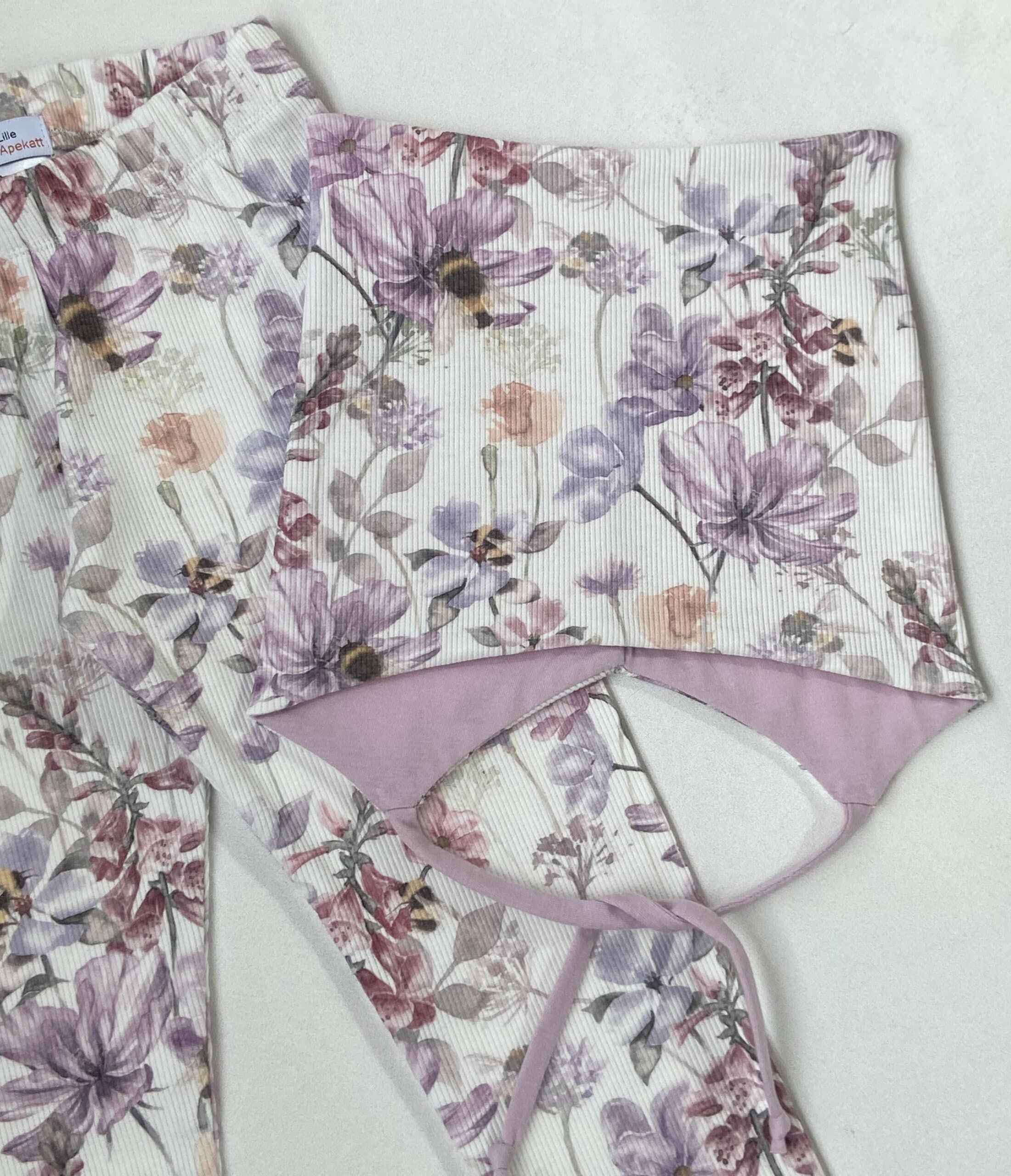 Lue med knyting, blomstereng. 4-12mnd